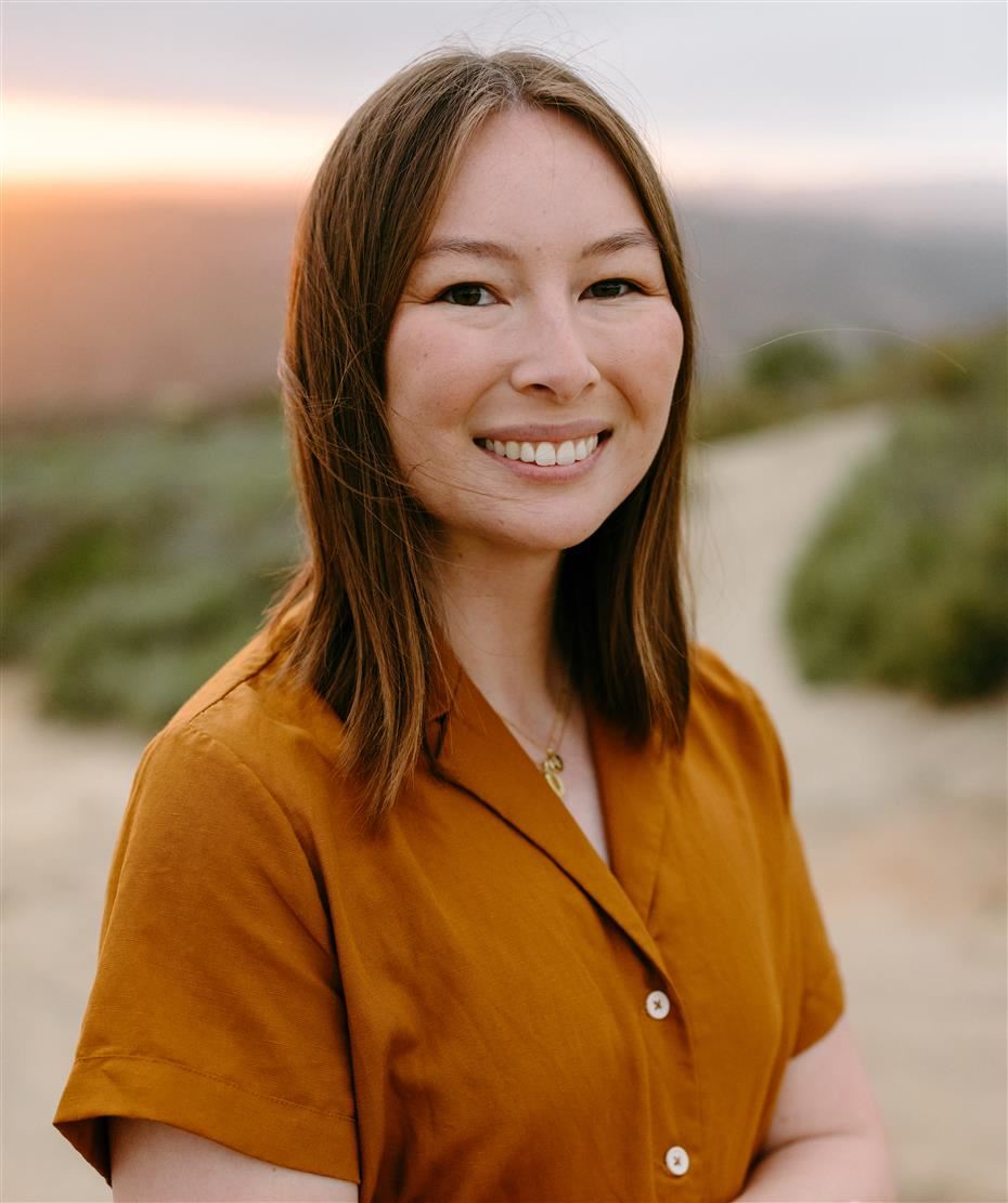 An image of Elise Johnson, the science teacher. She is wearing a brown button up shirt and is facing the camera smiling.